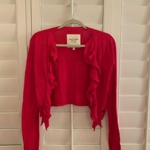bright red open cardigan with ruffles down middle.